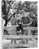 Smiling happy family mother father toddler boy portrait by farm fence by Anonymous