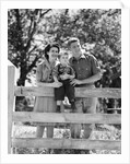 Smiling happy family mother father toddler boy portrait by farm fence by Anonymous