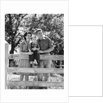 Smiling happy family mother father toddler boy portrait by farm fence by Anonymous