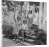 Family group of people standing on steps of house waving by Anonymous