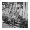 Family group of people standing on steps of house waving by Anonymous
