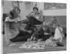 Family mother kids playing board game living room floor father reading newspaper by Anonymous