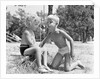 Blonde boy girl wearing bathing suits blowing on a pinwheel toy summer by Anonymous