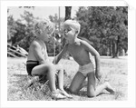 Blonde boy girl wearing bathing suits blowing on a pinwheel toy summer by Anonymous