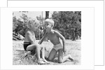 Blonde boy girl wearing bathing suits blowing on a pinwheel toy summer by Anonymous