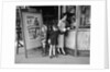 Mother and 2 children buying tickets to movie matinee boy wearing cowboy costume by Anonymous