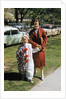 Mother with son dressed in clown suit outdoors by Anonymous