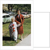 Mother with son dressed in clown suit outdoors by Anonymous