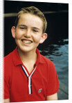 Portrait young boy in red shirt smiling by Anonymous