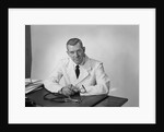 Portrait male doctor sitting at desk serious expression by Anonymous