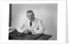 Portrait male doctor sitting at desk serious expression by Anonymous