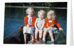 Boy and two girls in red sweaters sitting in back of rowboat by Anonymous