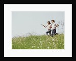 Young teen couple boy girl running field wildflowers by Anonymous