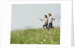 Young teen couple boy girl running field wildflowers by Anonymous