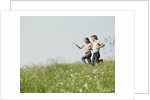 Young teen couple boy girl running field wildflowers by Anonymous