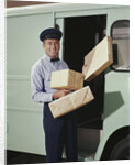 Delivery truck driver holding packages by Anonymous