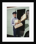 Delivery truck driver holding packages by Anonymous