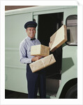 Delivery truck driver holding packages by Anonymous