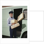 Delivery truck driver holding packages by Anonymous