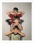 Boys posing as three wise monkeys see no evil hear no evil speak no evil by Corbis