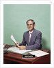 Smiling man at desk holding papers with mortgage officer sign looking at camera by Anonymous