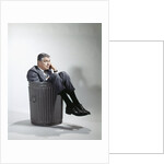 Sad man in business suit sitting in trash garbage can by Anonymous