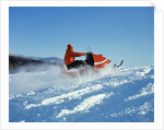 Man wearing red jacket and hat driving snowmobile by Anonymous