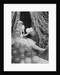 Woman dressed in harlequin costume sitting on stack of balloons by Anonymous