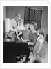 Family standing around piano singing by Anonymous