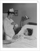 Woman nurse checking pulse taking temperature on little girl patient in hospital bed by Anonymous