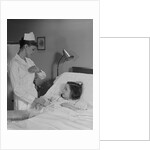 Woman nurse checking pulse taking temperature on little girl patient in hospital bed by Anonymous