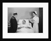 Man doctor woman nurse talking with male patient lying in hospital bed by Anonymous
