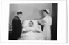 Man doctor woman nurse talking with male patient lying in hospital bed by Anonymous