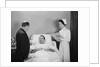 Man doctor woman nurse talking with male patient lying in hospital bed by Anonymous