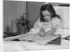 Little girl patient in hospital bed writing in coloring book by Anonymous
