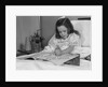 Little girl patient in hospital bed writing in coloring book by Anonymous