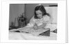 Little girl patient in hospital bed writing in coloring book by Anonymous