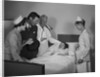 Man doctor woman nurse mother father seeing visiting smiling little girl patient in hospital bed by Anonymous