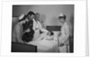 Man doctor woman nurse mother father seeing visiting smiling little girl patient in hospital bed by Anonymous