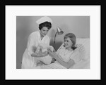 Woman nurse giving baby to smiling mother patient sitting in hospital bed by Anonymous
