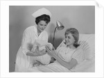 Woman nurse giving baby to smiling mother patient sitting in hospital bed by Anonymous