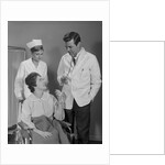 Man doctor woman nurse talking to smiling female patient sitting in hospital wheelchair by Anonymous