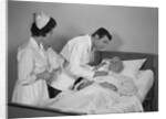 Doctor and nurse checking on elderly male patient in hospital bed by Anonymous