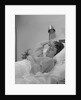 Ailing woman patient lying in hospital bed hand pressed to forehead by Anonymous