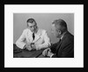 Doctor sitting at desk talking to male patient by Anonymous