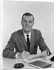 Smiling happy businessman pen in hand signing papers at desk by Anonymous