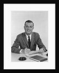 Smiling happy businessman pen in hand signing papers at desk by Anonymous