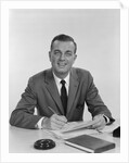 Smiling happy businessman pen in hand signing papers at desk by Anonymous