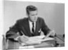 Businessman at desk looking over files papers making notes with pencil by Anonymous