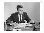 Businessman at desk looking over files papers making notes with pencil by Anonymous